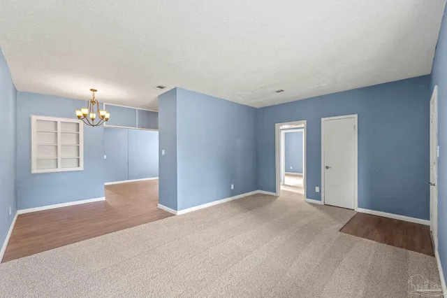 a view of an empty room with a chandelier