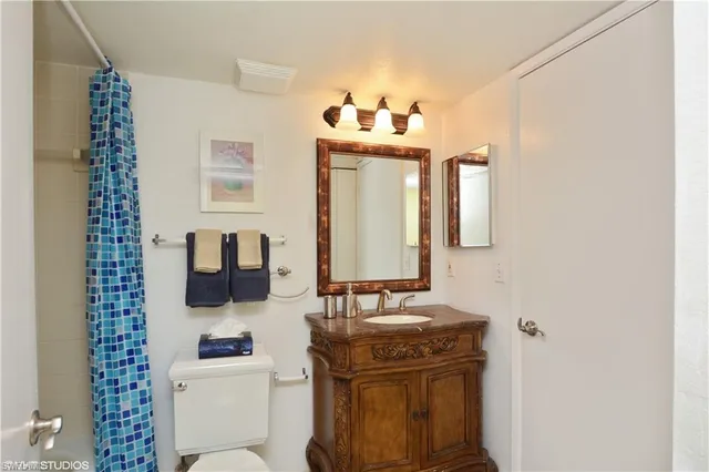 a bathroom with a toilet sink and mirror