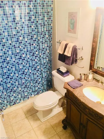 a bathroom with a granite countertop toilet a sink and a mirror