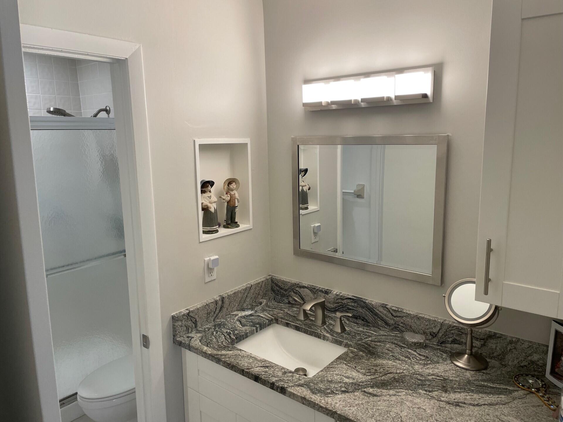 8471 Boca Glades Boulevard East Boca Raton, FL 33434 - Photo 14 of 29 a bathroom with a granite countertop sink toilet and mirror