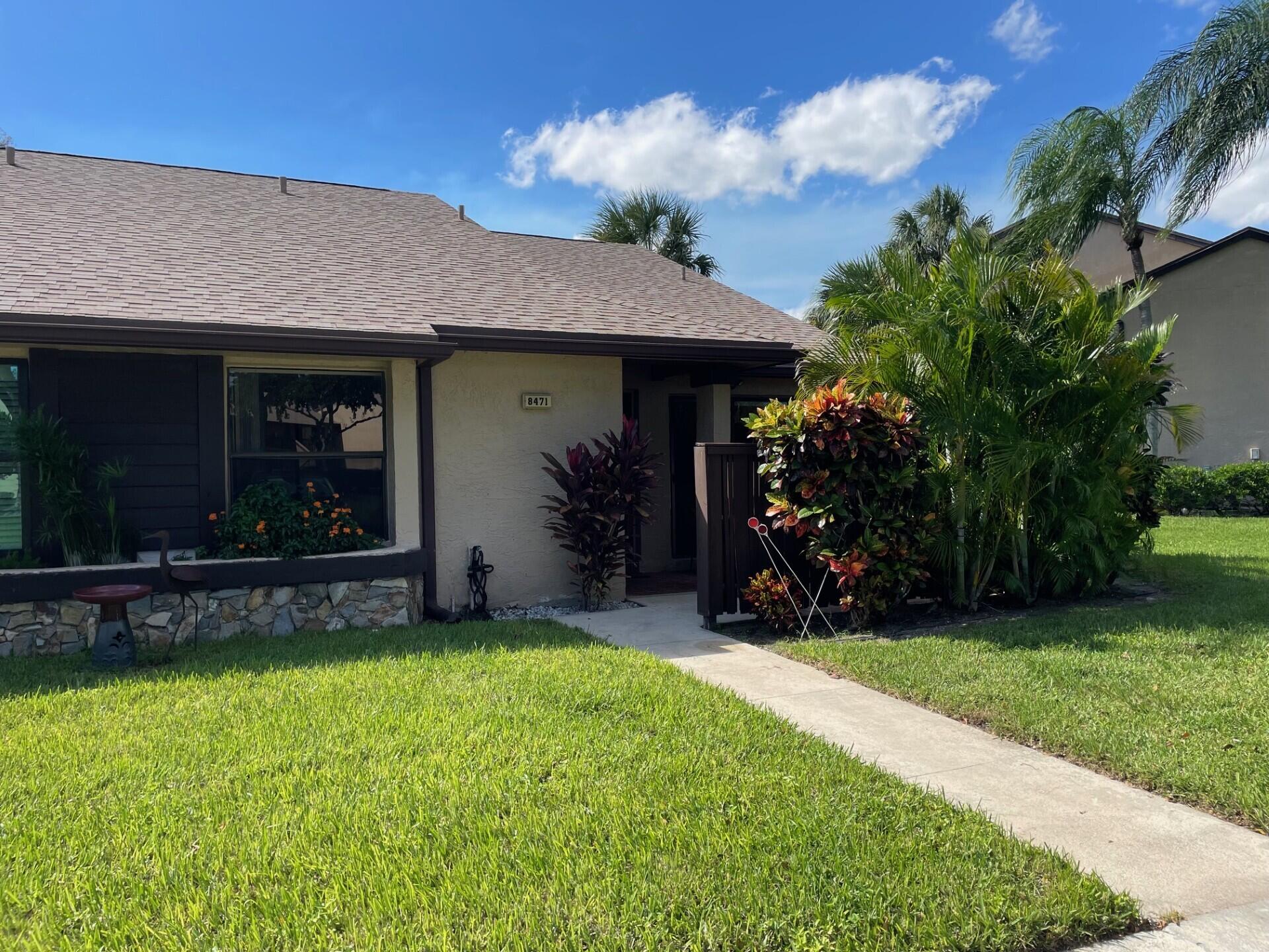 8471 Boca Glades Boulevard East Boca Raton, FL 33434 - Photo 2 of 29 a view of a house with potted plants and a yard