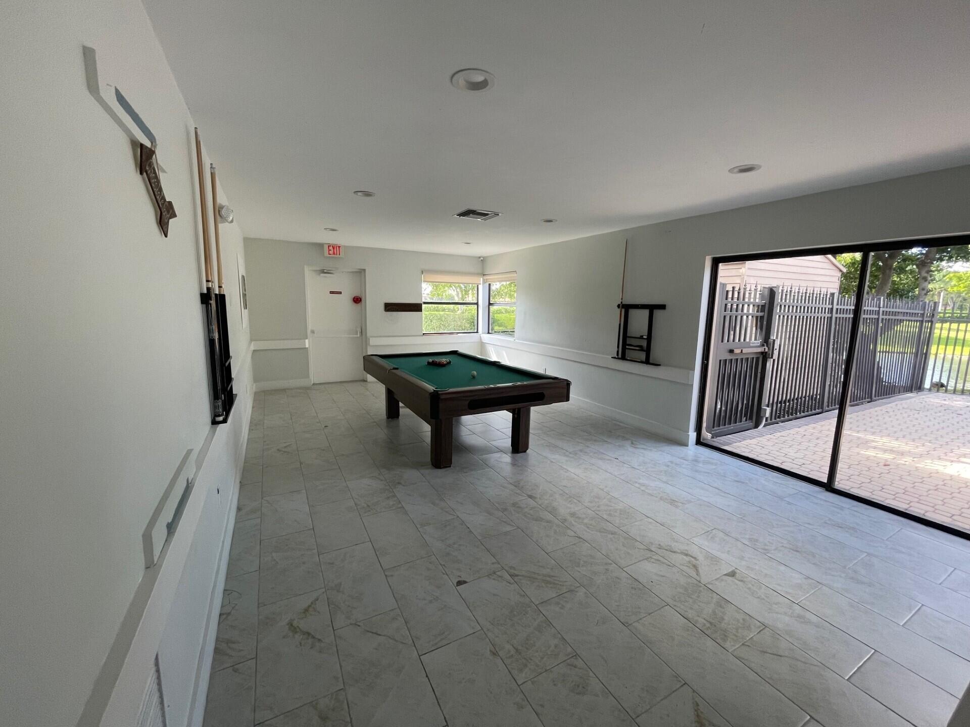 8471 Boca Glades Boulevard East Boca Raton, FL 33434 - Photo 24 of 29 a room with wooden floor and furniture