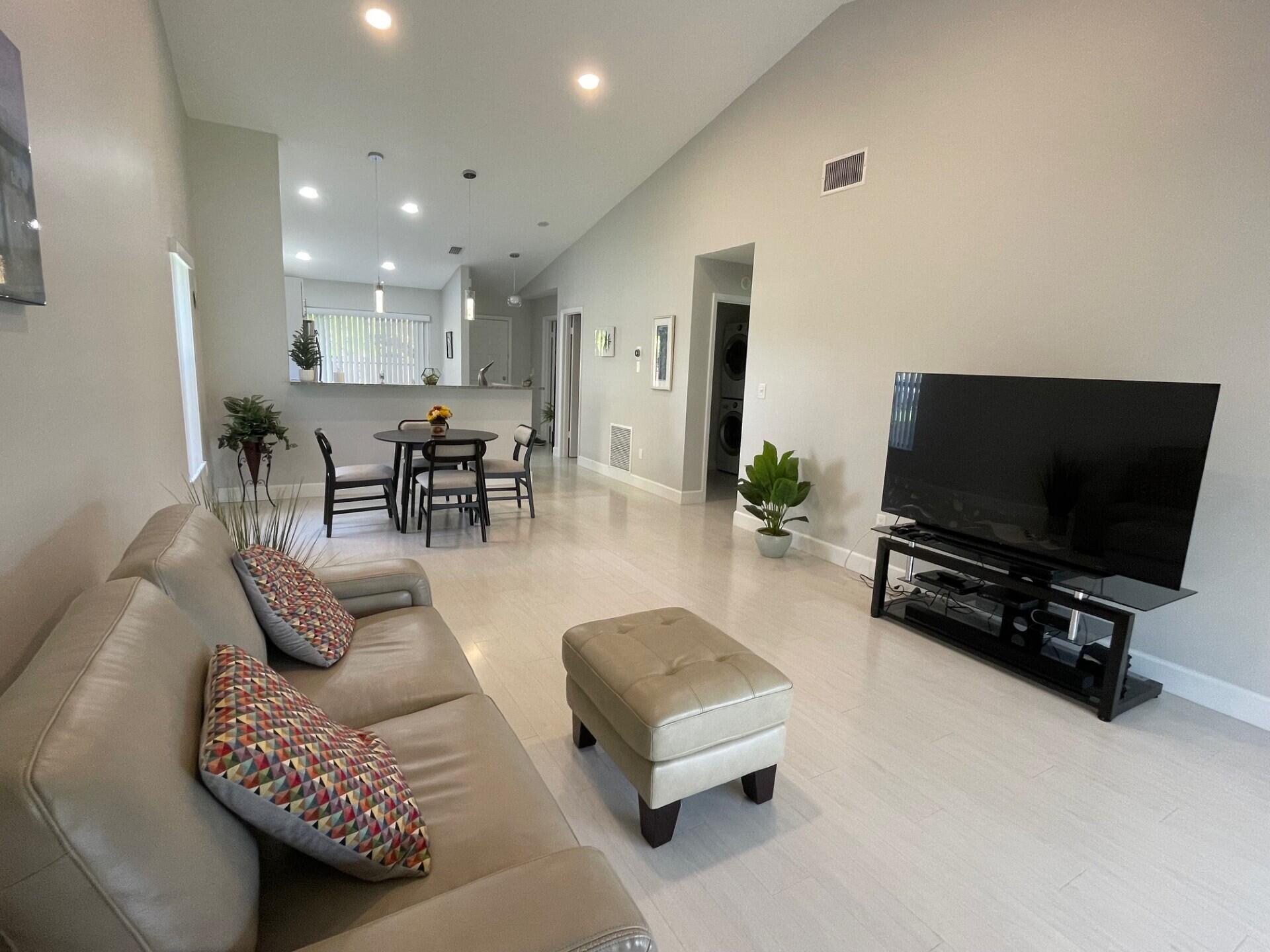 8471 Boca Glades Boulevard East Boca Raton, FL 33434 - Photo 8 of 29 a living room with furniture and a flat screen tv