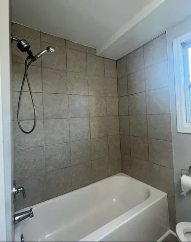 a bathroom with a bath tub with a shower