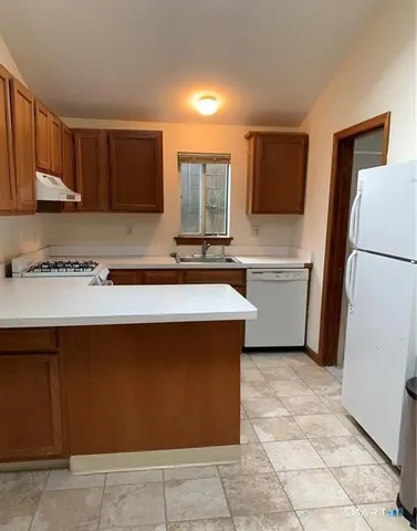 a kitchen with a sink a stove top oven and cabinetry