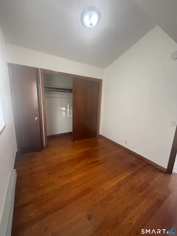 an empty room with closet and windows