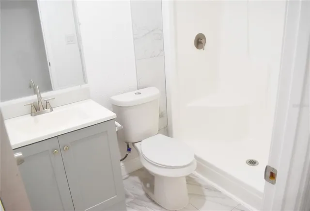 a white toilet sitting next to a bathroom sink