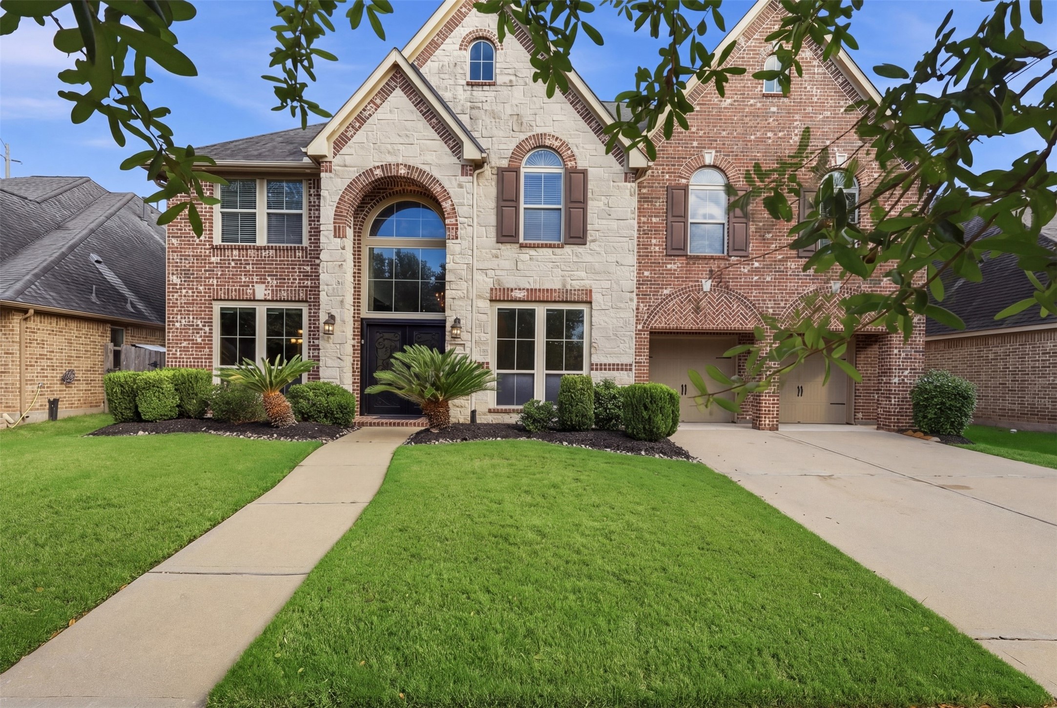 4130 Clover Ridge Lane Sugar Land, TX 77479 - Photo 3 of 48 This stunning two-story brick and stone Perry home features elegant arched windows, double upgraded front doors, beautifully landscaped front yard and a spacious driveway. The warm exterior lighting enhances its curb appeal.