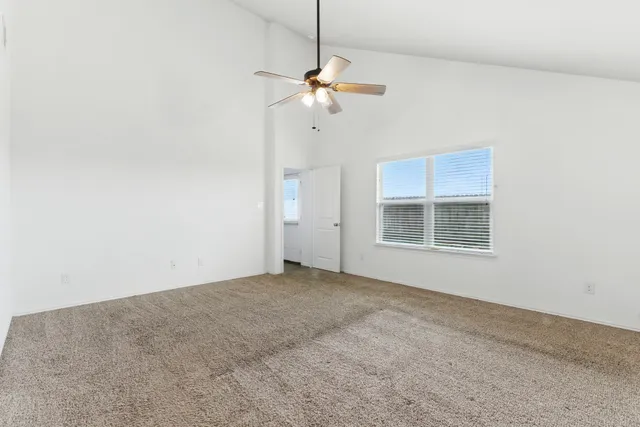 a view of a livingroom with a ceiling fan and window