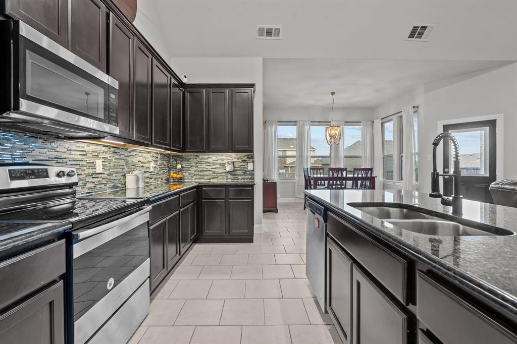 a kitchen with granite countertop a sink stove and cabinets