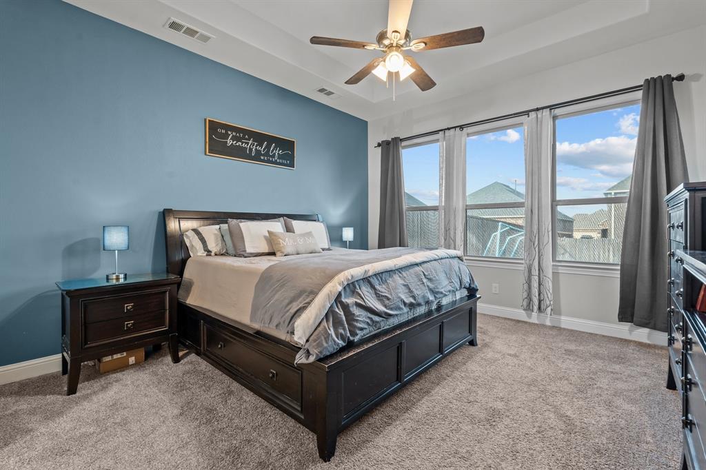 220 Flower Ridge Drive Fort Worth, TX 76108 - Photo 19 of 34 a bedroom with a large bed and a chandelier