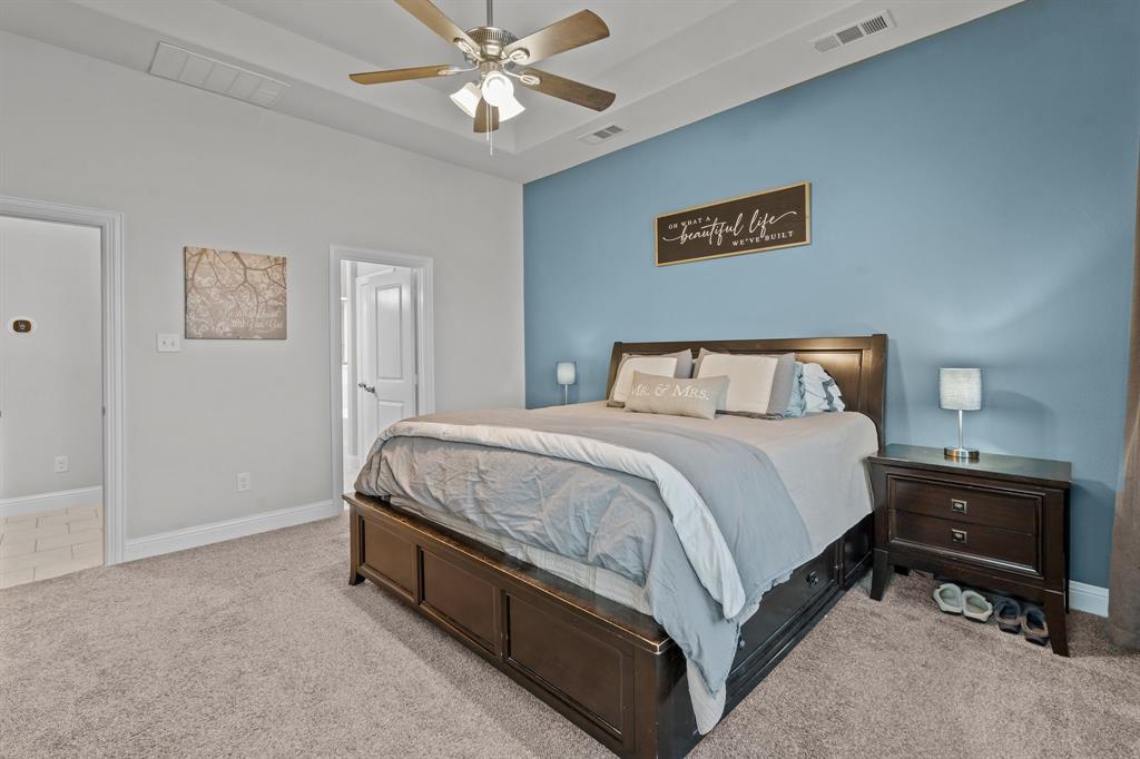 220 Flower Ridge Drive Fort Worth, TX 76108 - Photo 20 of 34 a bedroom with a bed and a chandelier