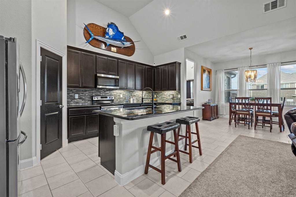 220 Flower Ridge Drive Fort Worth, TX 76108 - Photo 2 of 34 a kitchen with stainless steel appliances kitchen island granite countertop a refrigerator and a stove top oven