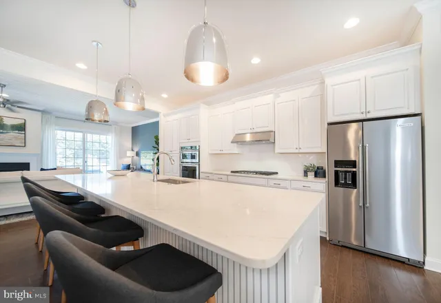 a kitchen with kitchen island a stove a table and chairs in it