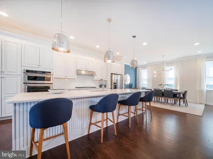 a kitchen with kitchen island a stove a table and chairs in it