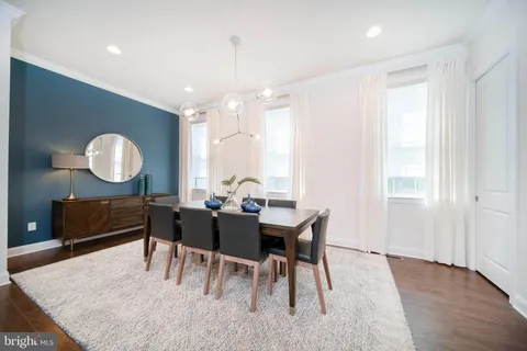 a dining room with wooden floor a glass table and chairs