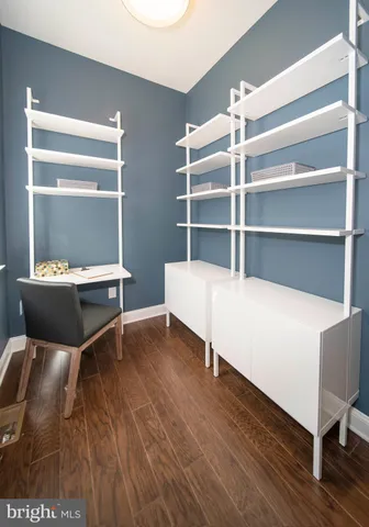 a open kitchen with stainless steel appliances granite countertop a stove a kitchen island a dining table and chairs with wooden floor