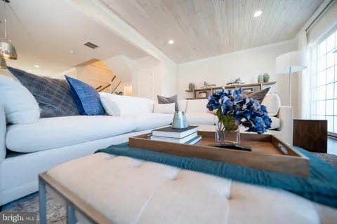 a open kitchen with stainless steel appliances granite countertop a stove a kitchen island a dining table and chairs with wooden floor