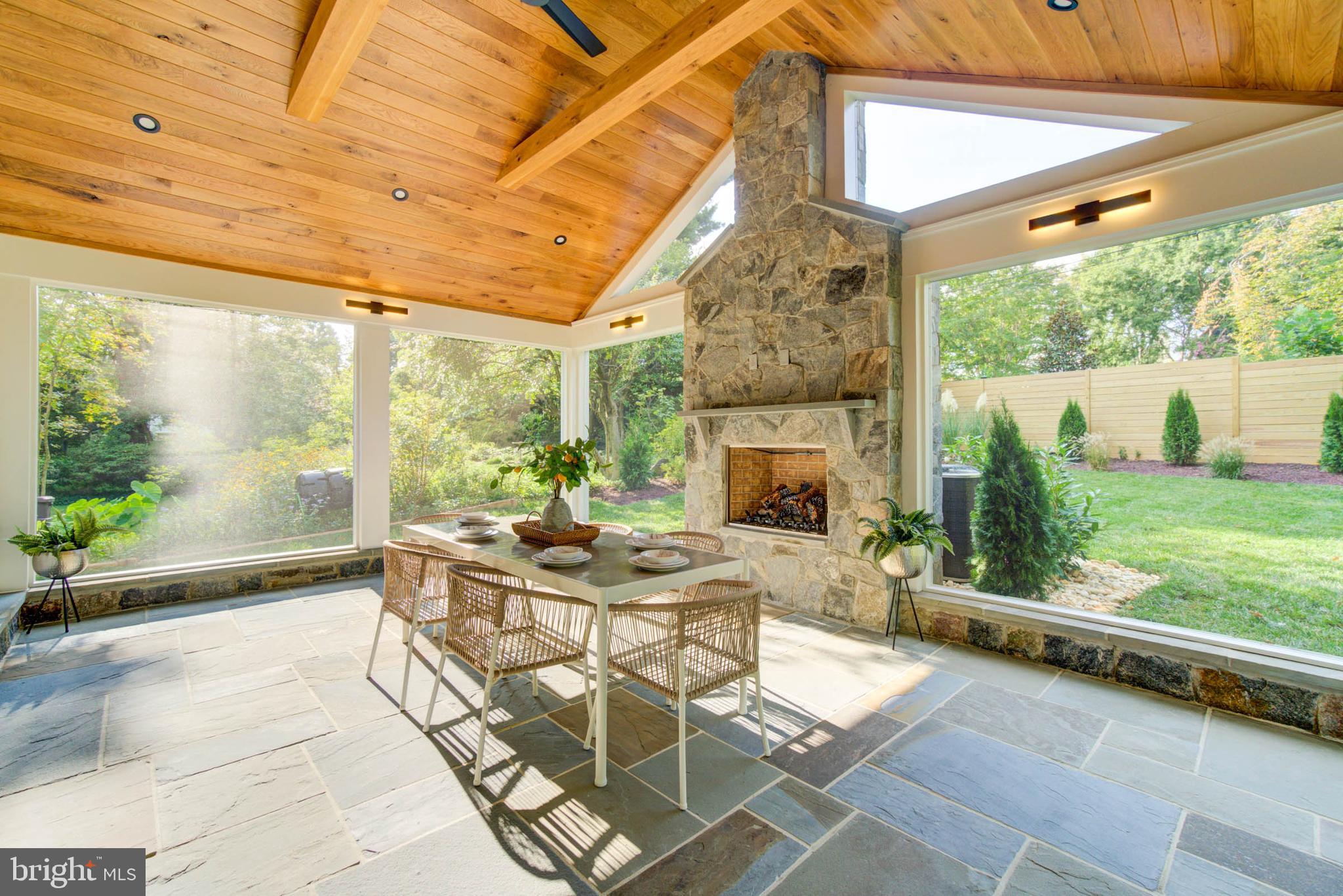 7818 Glenbrook Road Bethesda, MD 20814 - Photo 39 of 95 a view of a patio with a table chairs and a floor to ceiling window