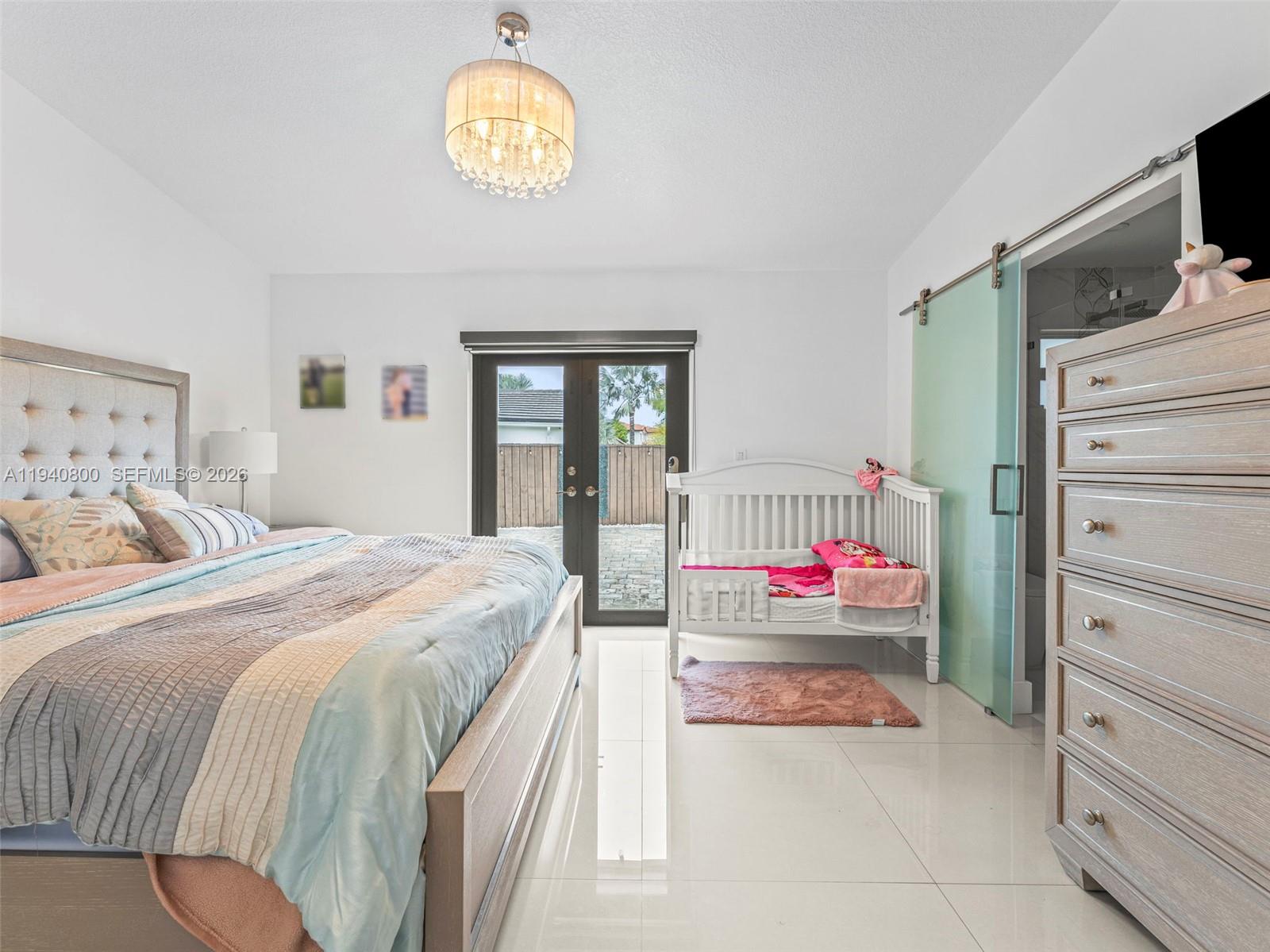 15805 Southwest 79th Terrace Miami, FL 33193 - Photo 19 of 50 a bedroom with a bed and a chandelier