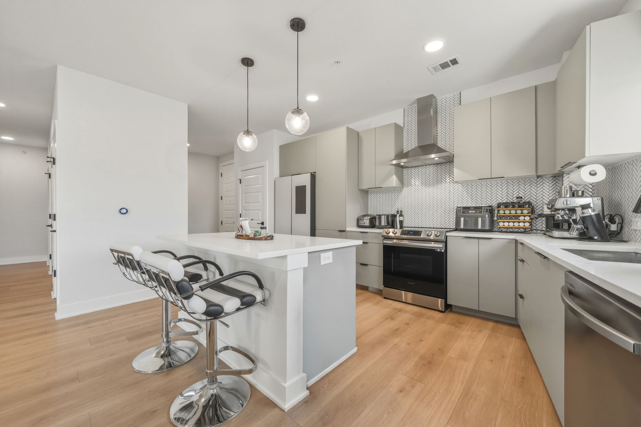 2500 Longview Street, Unit 300 Austin, TX 78705 - Photo 5 of 36 a kitchen with kitchen island a dining table chairs stainless steel appliances and cabinets