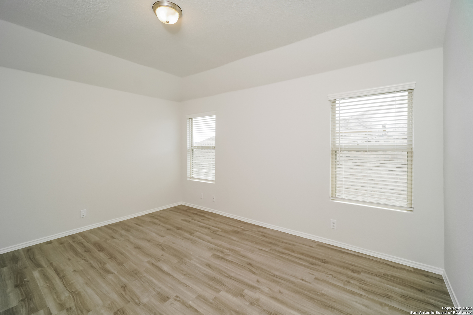 5231 Blue Ranch San Antonio, TX 78222 - Photo 12 of 16 an empty room with wooden floor and windows