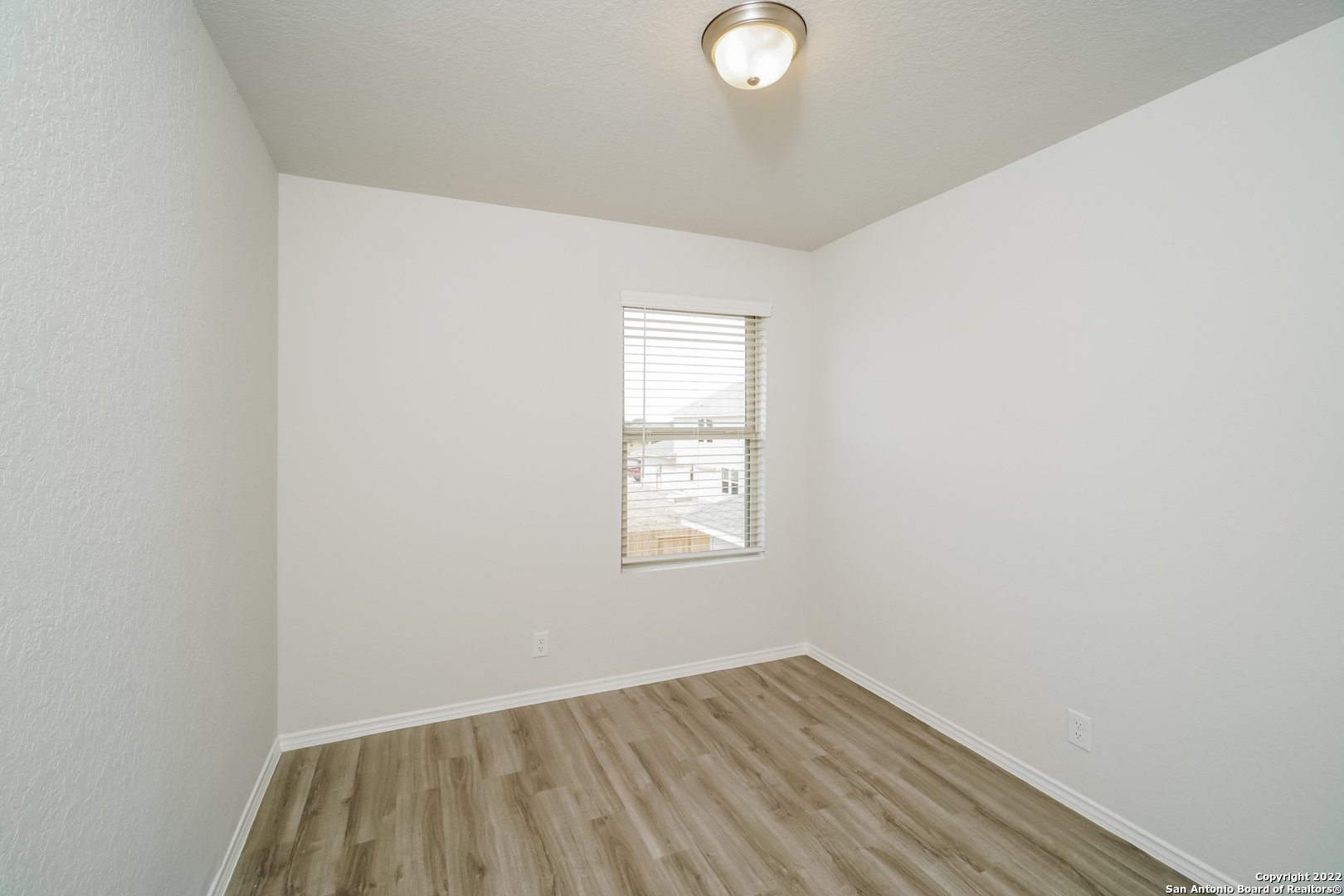 5231 Blue Ranch San Antonio, TX 78222 - Photo 10 of 16 an empty room with wooden floor and windows