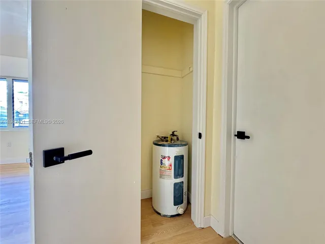 a view of a hallway with wooden floor and closet