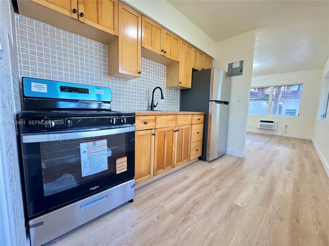 a kitchen with stainless steel appliances wooden floor sink and wooden cabinets