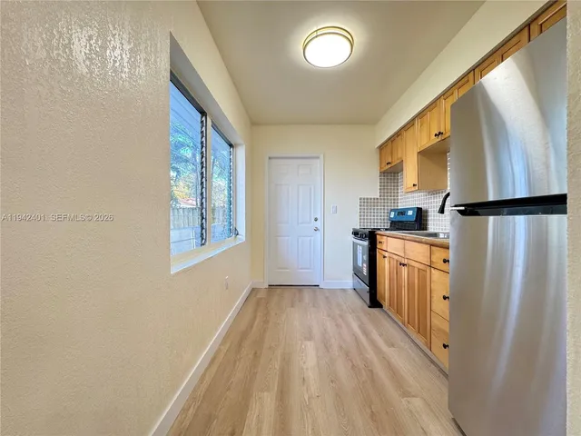 a kitchen with white cabinets and refrigerator