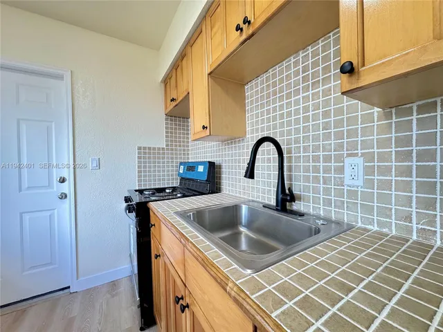 a close view of a sink and dishwasher with wooden floor