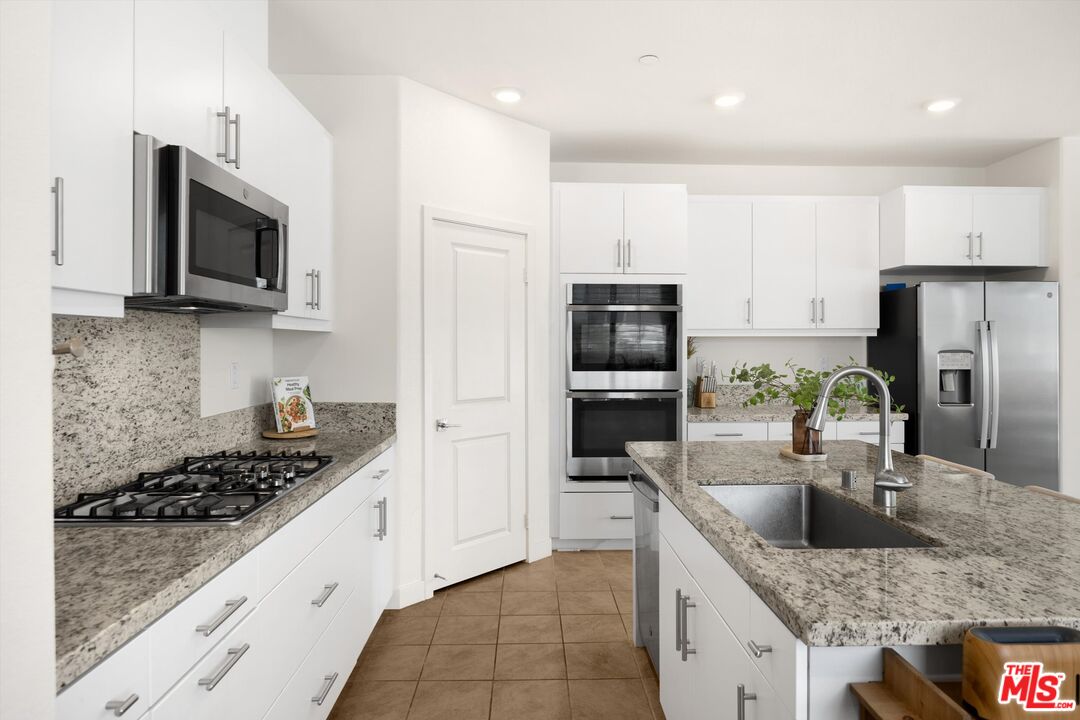 519 Tucker Avenue Rialto, CA 92377 - Photo 12 of 45 a kitchen with stainless steel appliances granite countertop a sink stove microwave and refrigerator