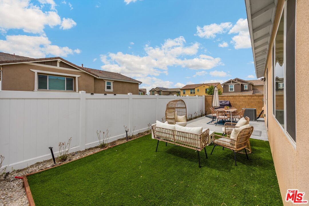 519 Tucker Avenue Rialto, CA 92377 - Photo 17 of 45 a view of a white house with a big yard and dinning table