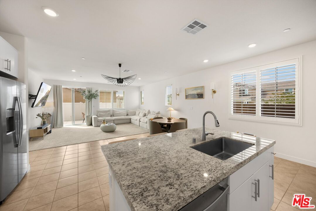 519 Tucker Avenue Rialto, CA 92377 - Photo 9 of 45 a kitchen with stainless steel appliances granite countertop a sink and white cabinets