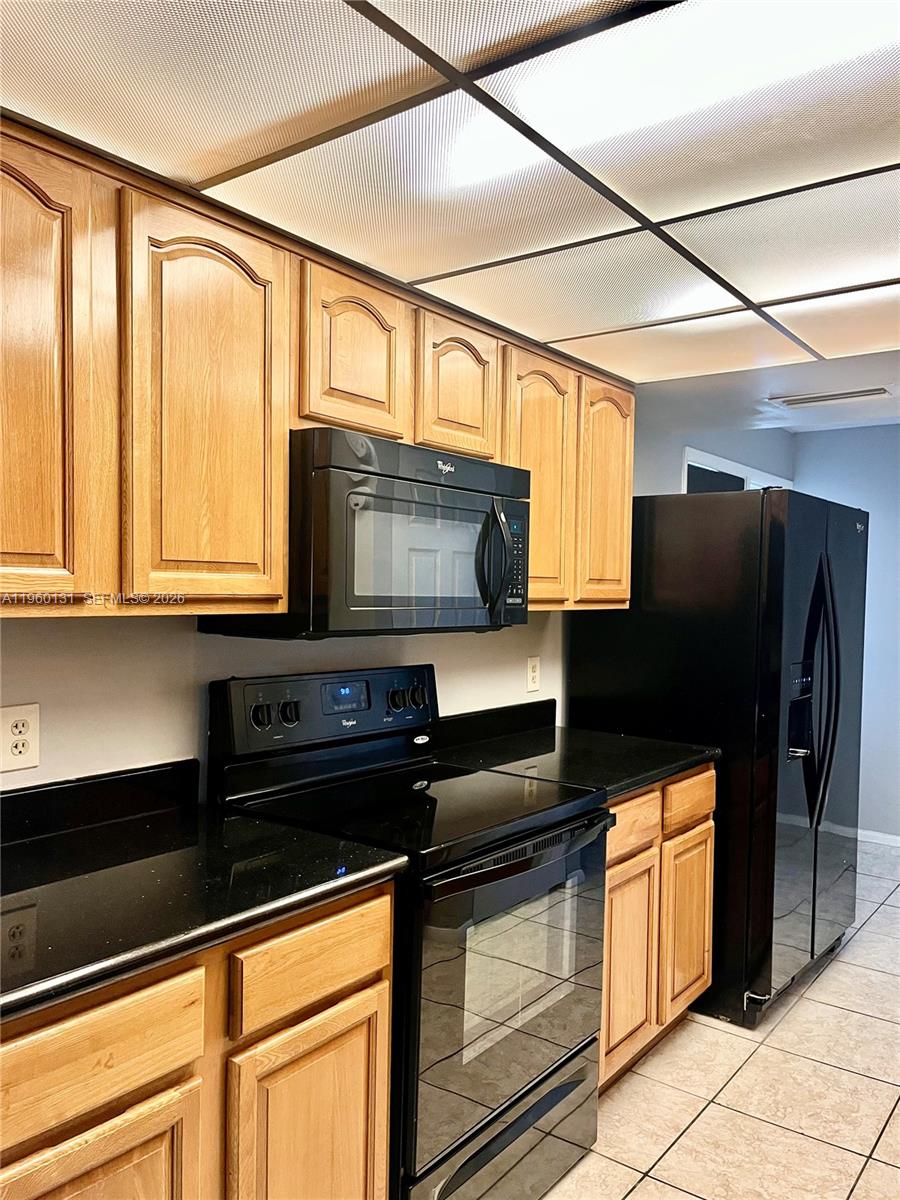 4575 South Texas Avenue, Unit 307 Orlando, FL 32839 - Photo 8 of 40 a kitchen with stainless steel appliances wooden cabinets and a stove top oven