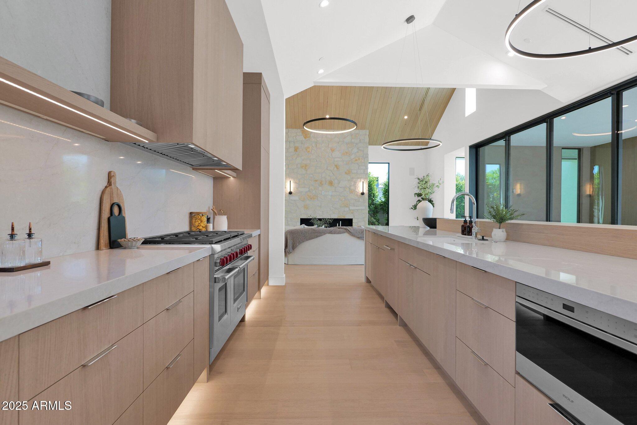 4704 North 40th Place Phoenix, AZ 85018 - Photo 23 of 65 a large kitchen with a large counter top a sink a stove and a wooden floor