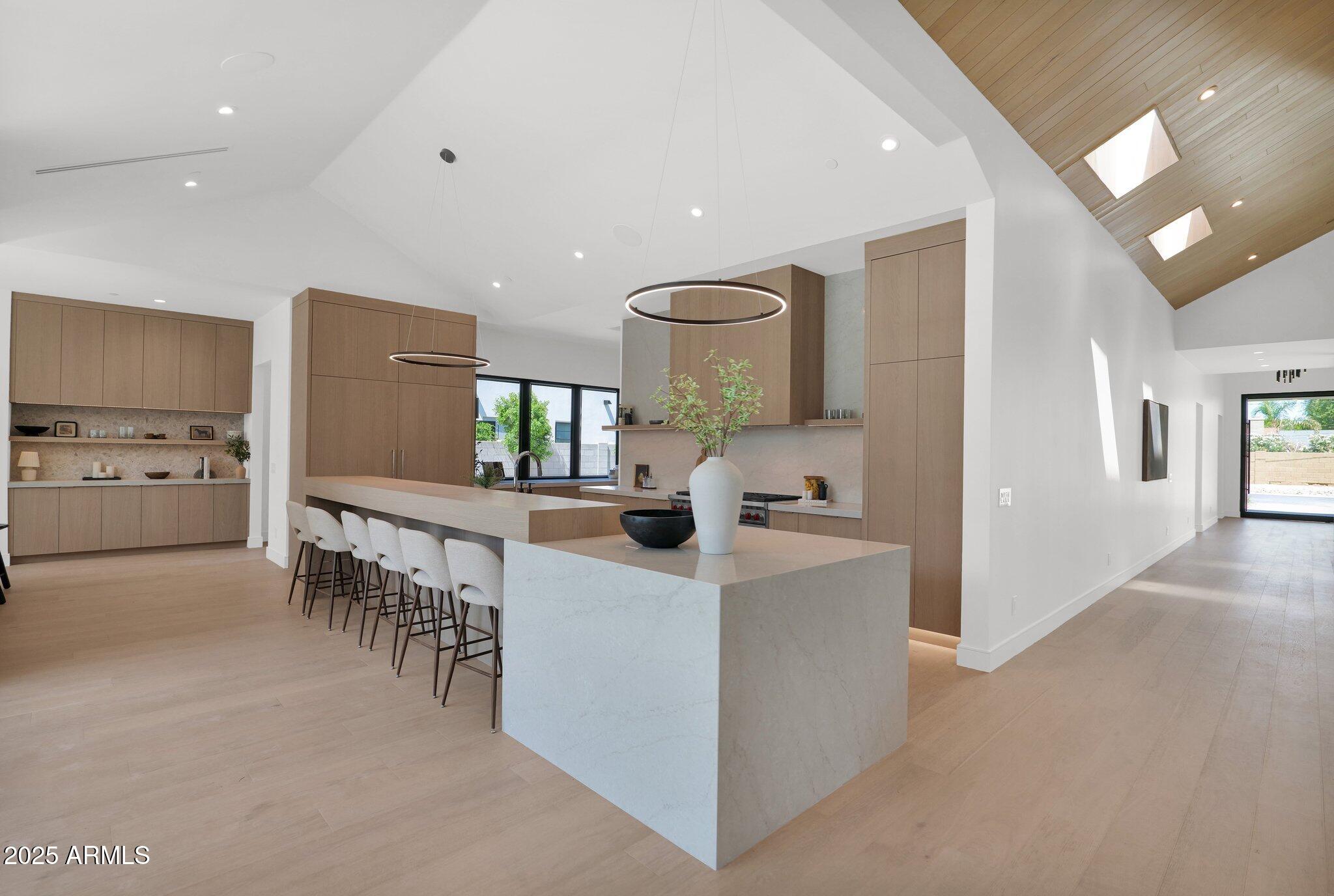 4704 North 40th Place Phoenix, AZ 85018 - Photo 25 of 65 a kitchen with kitchen island a sink counter and chairs
