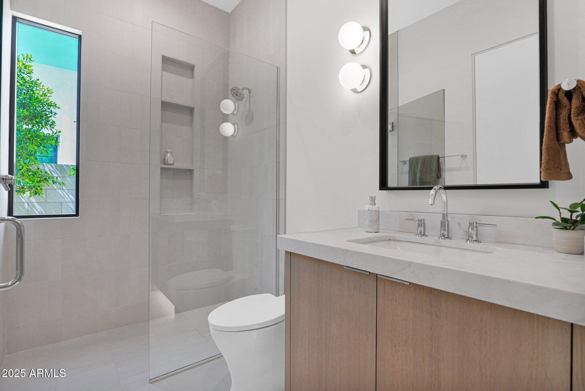 4704 North 40th Place Phoenix, AZ 85018 - Photo 43 of 65 a bathroom with a granite countertop sink a toilet and a mirror