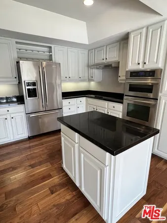 a kitchen with granite countertop a sink and steel appliances