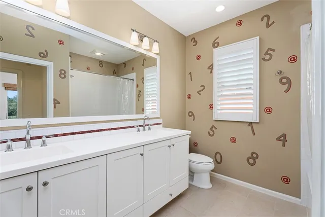 a bathroom with a double vanity sink mirror and toilet