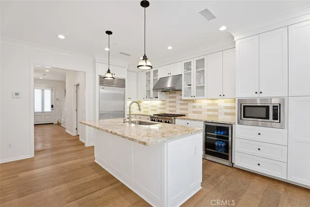 a large kitchen with stainless steel appliances and white cabinets