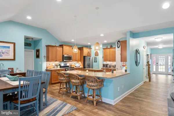 a kitchen with stainless steel appliances granite countertop a sink a stove and a wooden cabinets