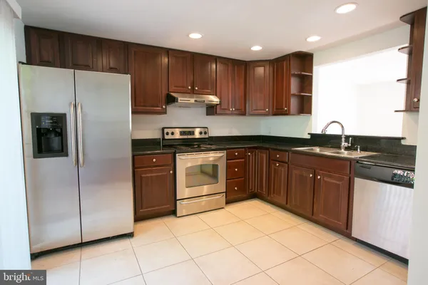 a kitchen with stainless steel appliances granite countertop a refrigerator sink and cabinets