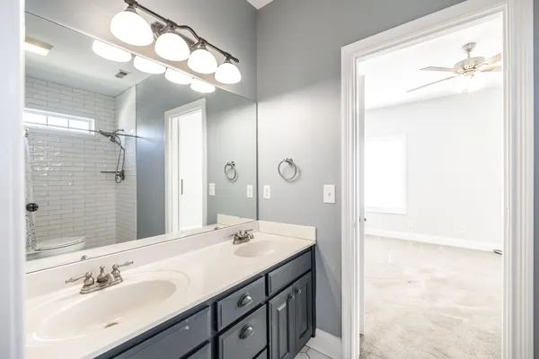 a bathroom with a double vanity sink and a mirror