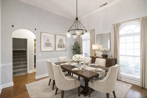 a dining room with furniture a chandelier and wooden floor