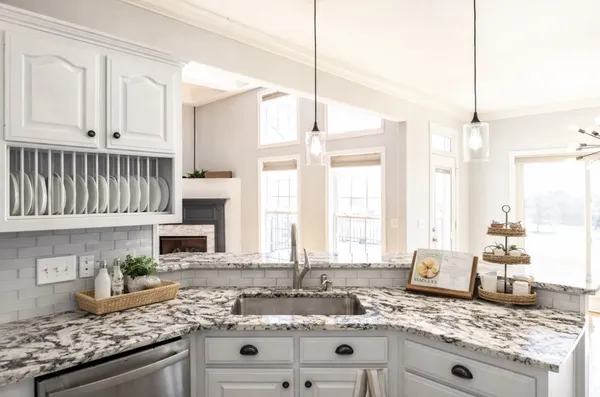a kitchen with granite countertop a sink a counter space appliances and cabinets