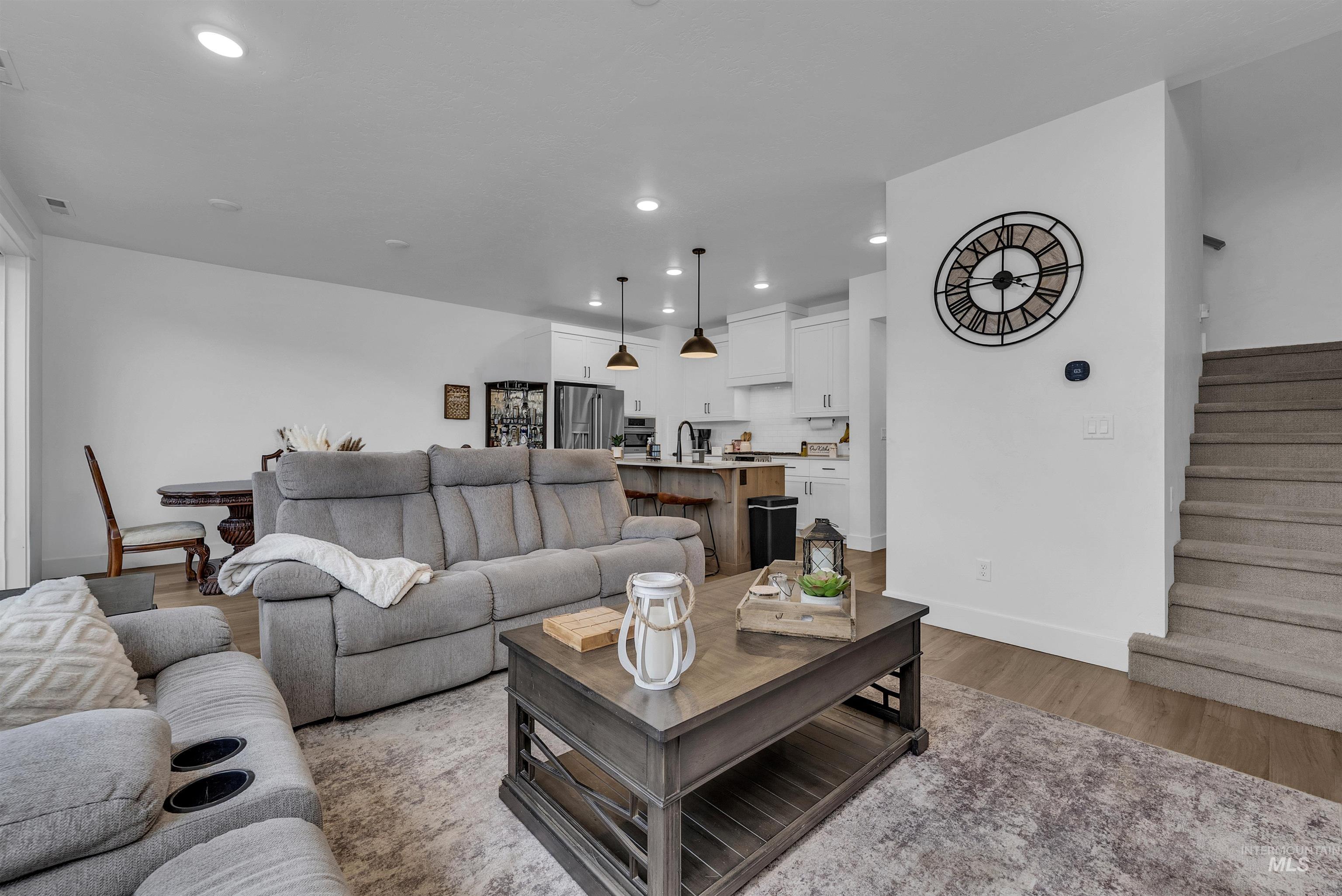 4678 West Riva Capri Street Meridian, ID 83646 - Photo 11 of 30 Living room featuring recessed lighting, light wood-style flooring, and stairway
