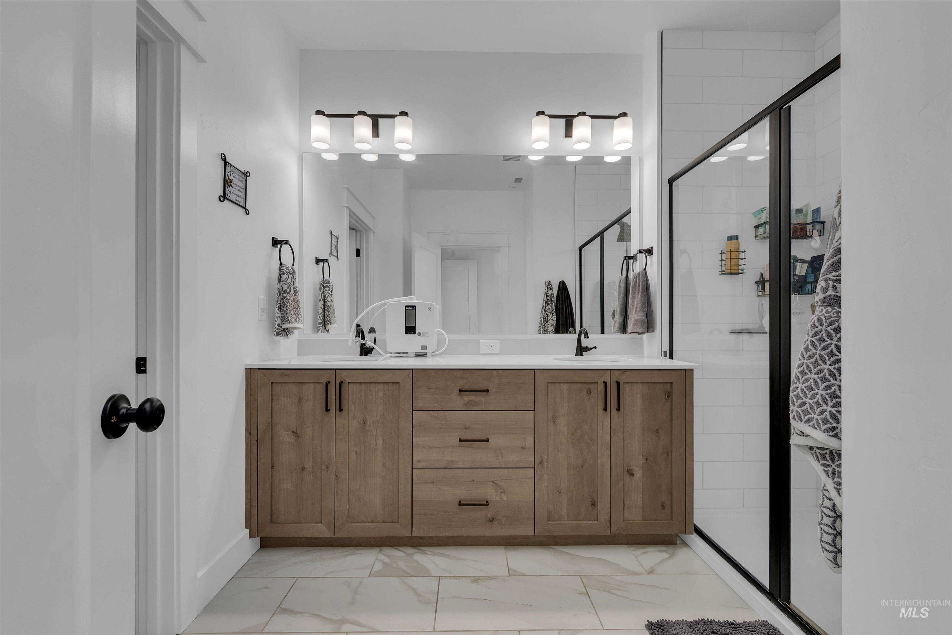4678 West Riva Capri Street Meridian, ID 83646 - Photo 16 of 30 Bathroom featuring double vanity, a shower stall, and light marble finish floors