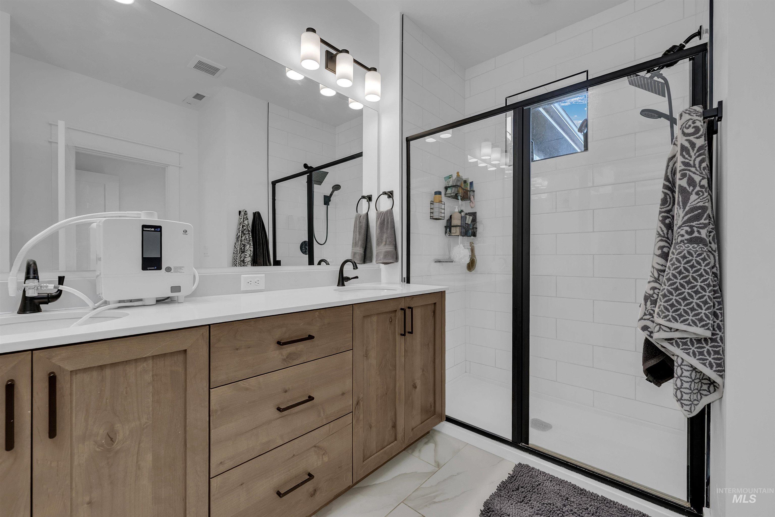 4678 West Riva Capri Street Meridian, ID 83646 - Photo 17 of 30 Full bath featuring double vanity, a stall shower, and light marble finish floors