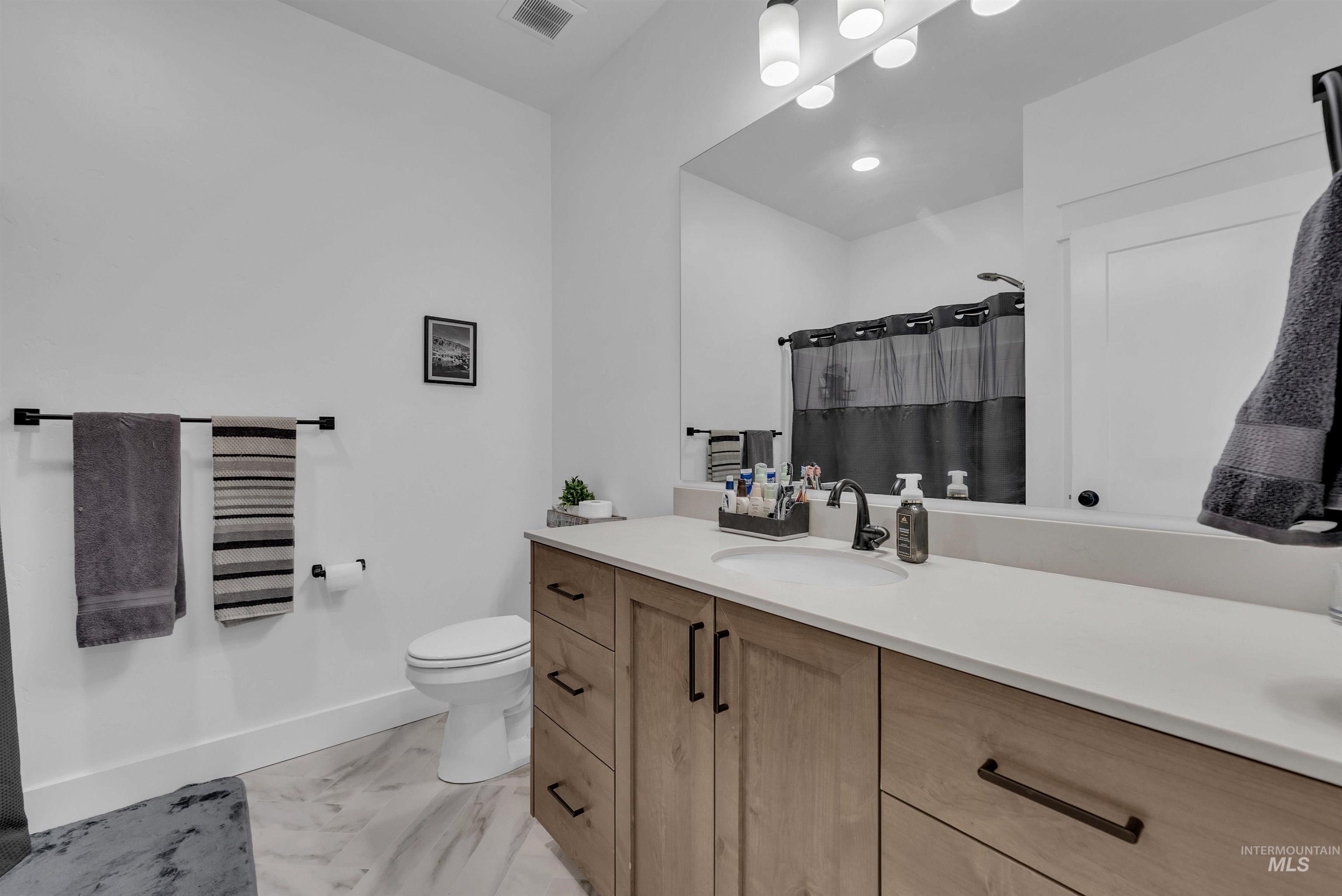 4678 West Riva Capri Street Meridian, ID 83646 - Photo 22 of 30 Bathroom featuring vanity, curtained shower, and light marble finish flooring